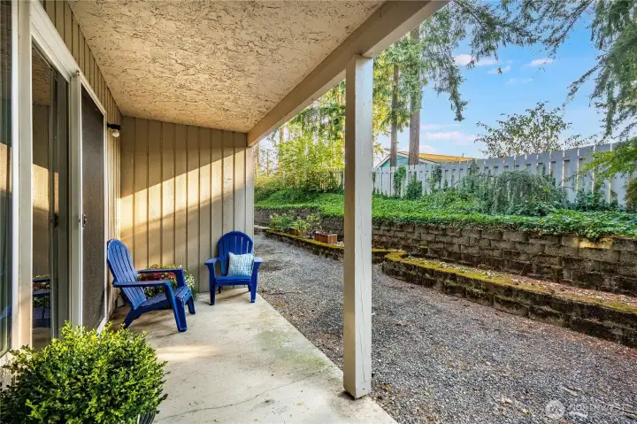 The covered patio has a private view, and is shaded by tall trees that stand behind the condo complex.