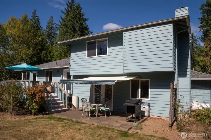 The covered patio with remote sunshade provides a comfortable outdoor gathering space, rain or shine.