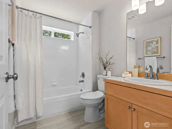 On the opposite side of the kitchen is a full bathroom. Conveniently located.