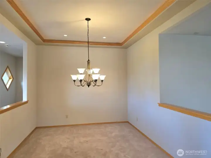 Dining room with recessed lighting, open to the living room.