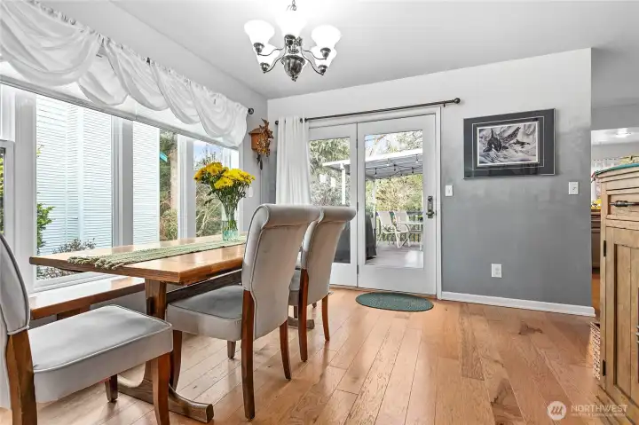 Dining room features hard wood floors with access to the partially covered wrap-around deck. Kitchen is right around the corner to your right.