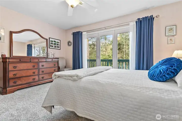 Private primary bedroom looks out to the creek with access to deck.