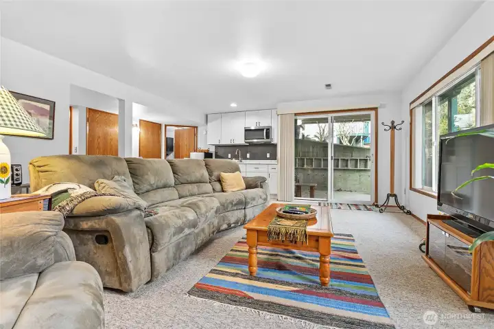 Daylight basement -Family room with kitchenette and large picture windows that look out to nature and the creek.  Cozy gas stove makes this space perfect to unwind! It is also a great space to have guests stay or rent out! Access door to covered patio.