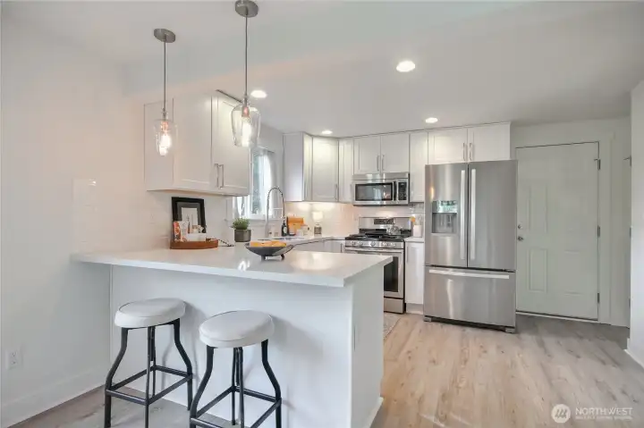 Enjoy the updated kitchen with quartz countertops, SS appliances (gas stove) and bar seating.