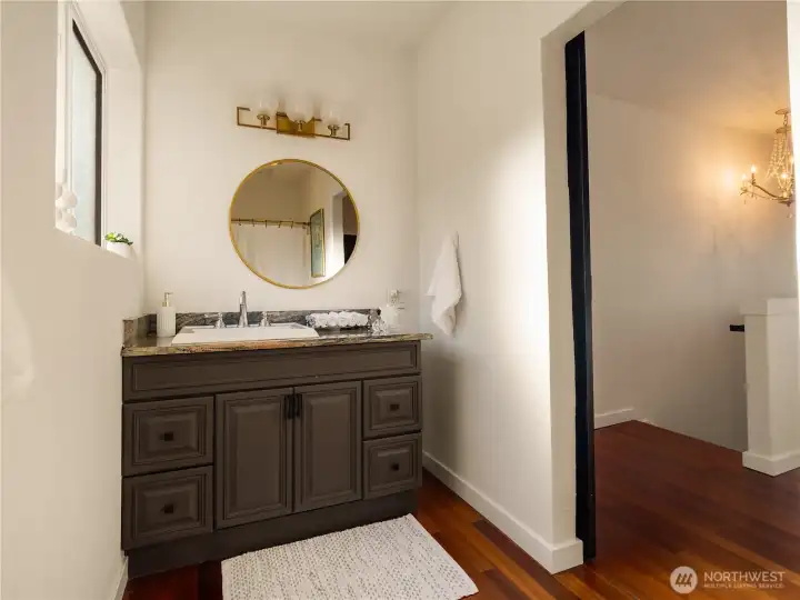 The primary bath has granite countertops and a stylish barn door.
