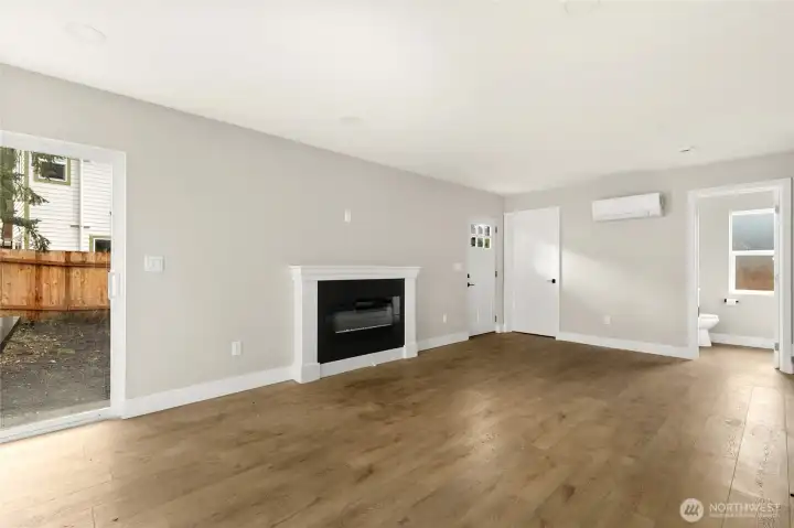 Open living space with cozy electric fireplace, main floor laundry and mechanical space.