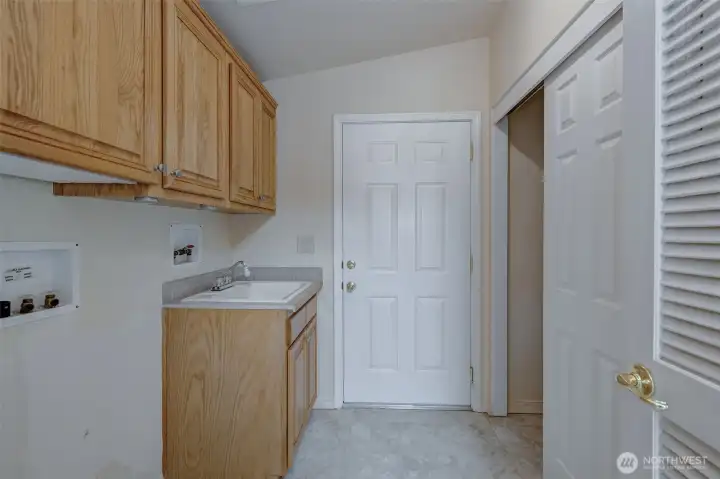 Well appointed utility room offers a utility sink, large coat closet, and ample storage!