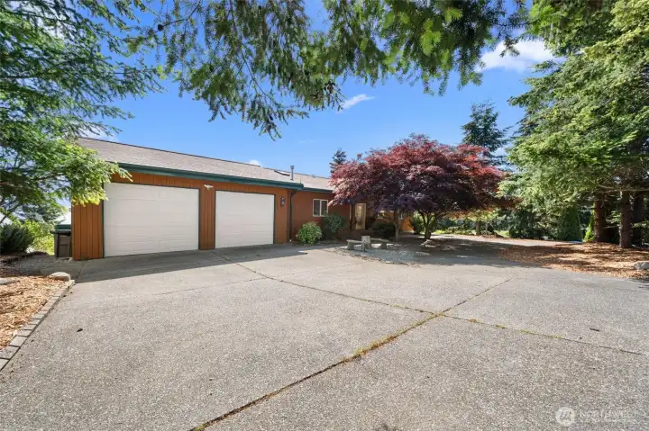 Welcoming circular driveway with convenient guest drop-off and ample parking plus attached two large car garage.