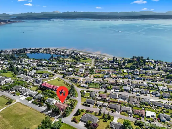 Aerial view showcasing the home's incredible location, sweeping views of Port Susan, Mt. Baker, and the Cascade Mountains, with access to three private community beaches.