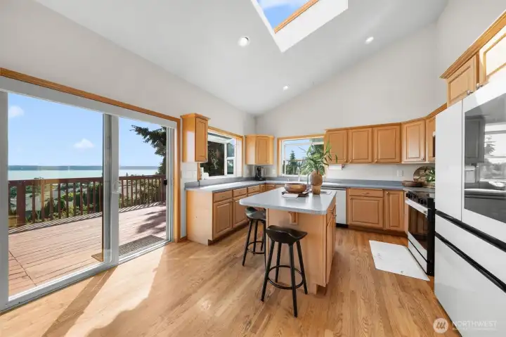 Bright and spacious kitchen featuring an island, skylight, brand-new high-end appliances, and direct access to the oversized view deck.
