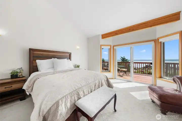 Wake up to breathtaking water and mountain views from the spacious main-floor primary suite with deck access.