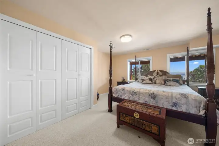 Oversized lower-level bedroom with large closets and water views, offering flexible use as a guest retreat or private living space.