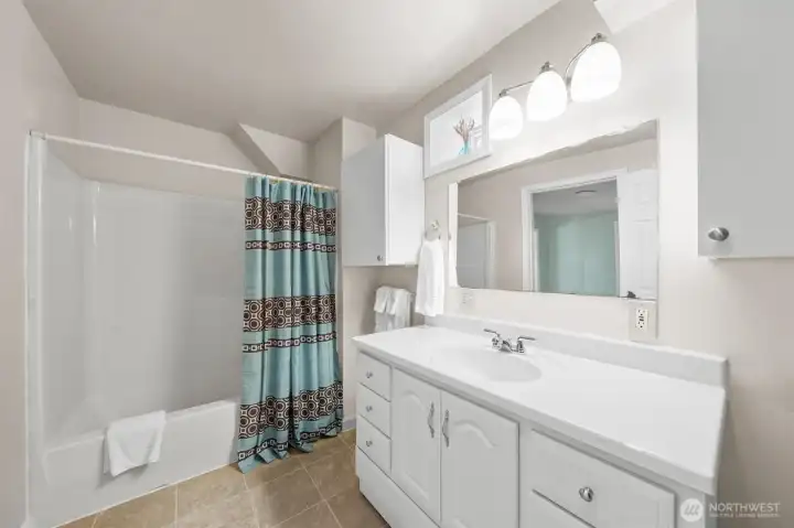 Convenient lower-level full bath serving the guest bedrooms, family room, and second kitchen.