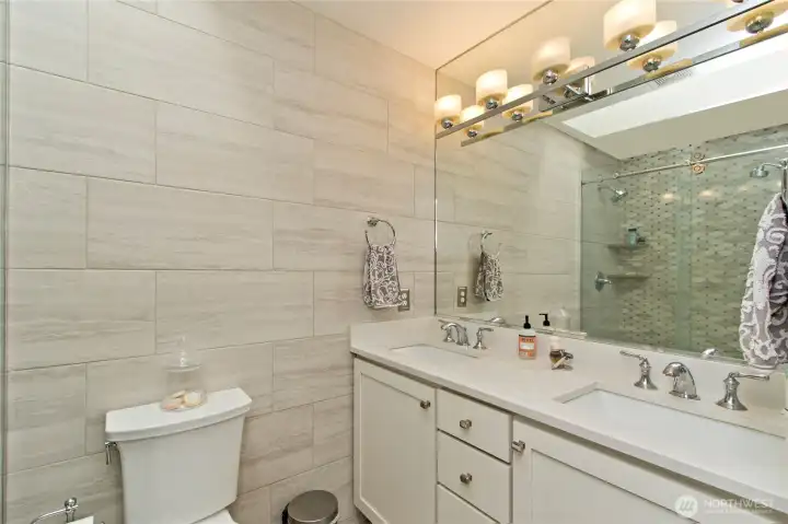 The Primary bath features natural marble, glass, plenty of light from the skylight and a 3cm thick Quartz countertop!