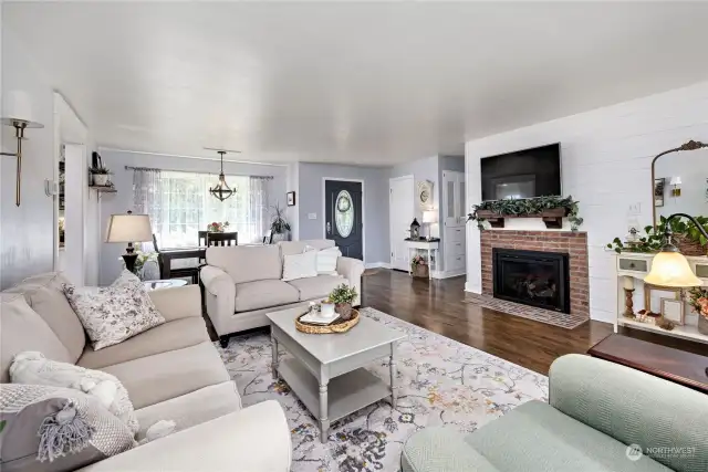 Living room w/natural gas fireplace and beautiful updated flooring, fresh paint & designer shiplap wall treatment.