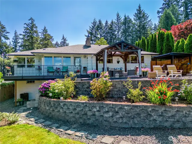 Expansive decking, covered seating and fire feature areas. Terraces for gardening and landscaping. Lower yard has gazebo, garden shed and firepit.