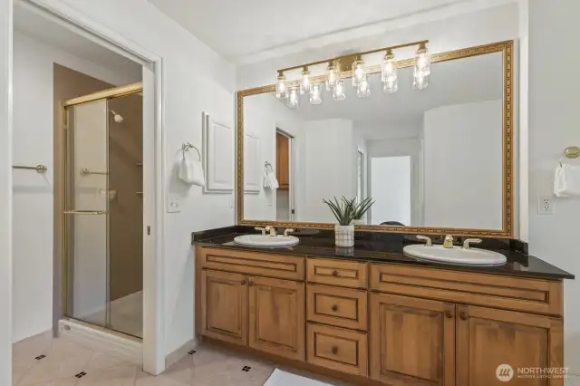 Primary bathroom with large soaking tub, maple vanity, granite counter and separate shower area.