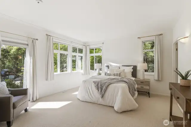 The spacious in-law bedroom with sconce lighting, door to the patio and backyard connects to the full bathroom.