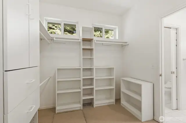 Huge walk-in closet with built-ins connects to the full bathroom.