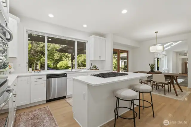 The everyday areas feature a new kitchen with shaker style cabinetry with brushed gold hardware, quartz counters and breakfast bar with seating.