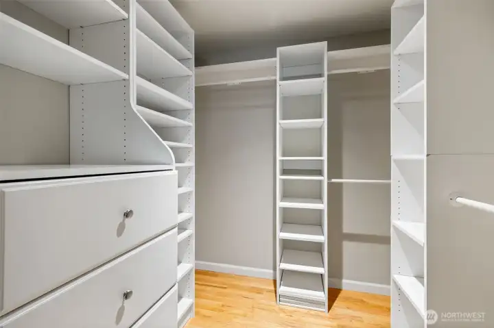 Walk in closet with custom organization and built in dresser.