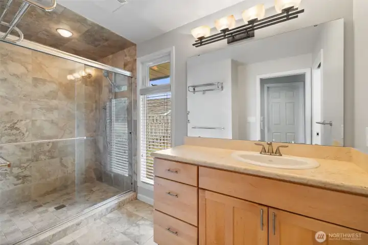 Main bath has a double vanity and separate water closet from shower. Travertine floors and shower surround.