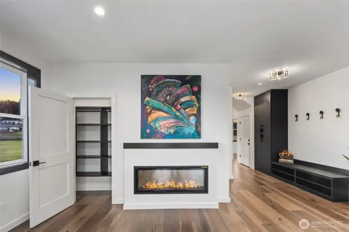Spacious great room with storage & electric fireplace.