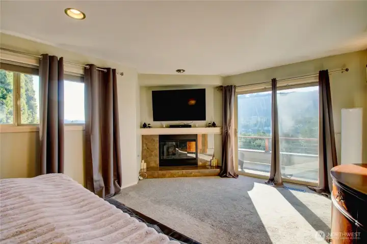 Main floor primary bedroom with gas fireplace and deck access.