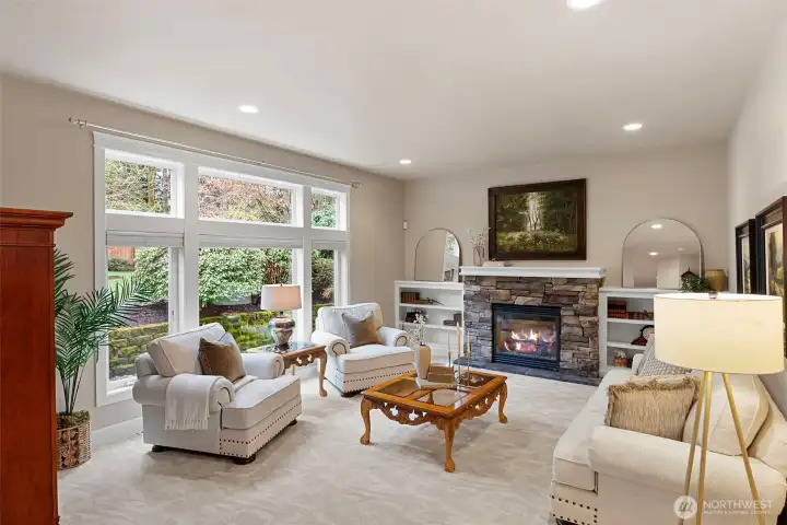Wall of windows grace the living room with gas fireplace