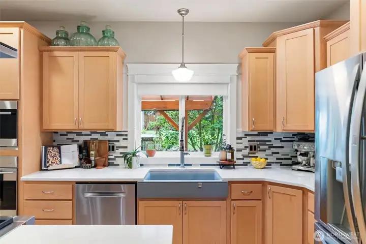 Kitchen overlooks lush backyard