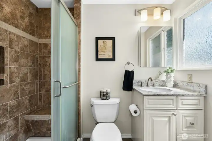 Updated primary bathroom with tiled shower and modern vanity. Updated primary bathroom with tiled shower and modern vanity.