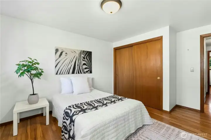 Bright secondary bedroom with hardwood flooring and ample closet space Bright secondary bedroom with hardwood flooring and ample closet space