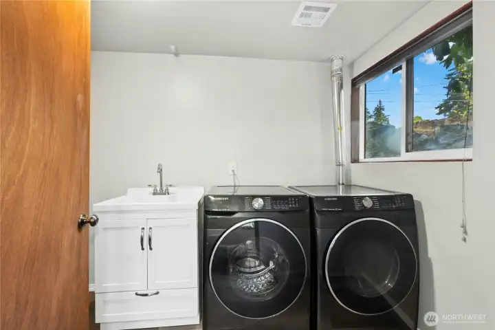 Dedicated laundry area with extra storage and utility space. Dedicated laundry area with extra storage and utility space.