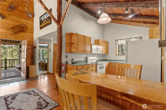 Eat in kitchen featuring a cafe style table milled from trees on site- practical, space efficient, and lending cabin charm.