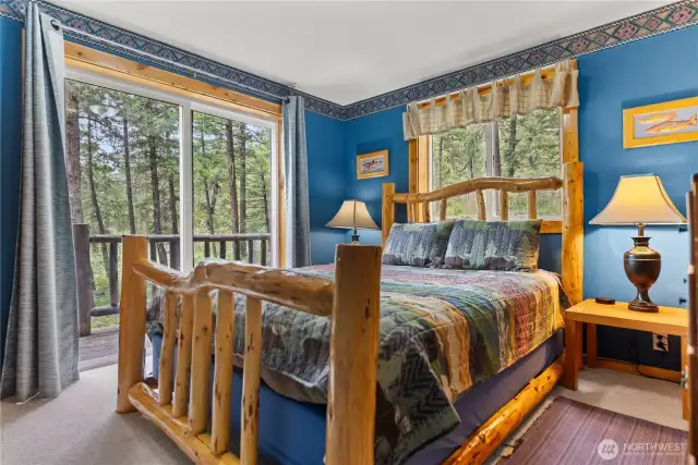 Main floor bedroom with sliding doors that open onto a wrap around deck.