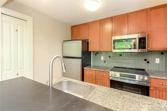 Attractive tile backsplash & granite countertops.  Cherry stained maple cabinetry is featured thruout the condo.