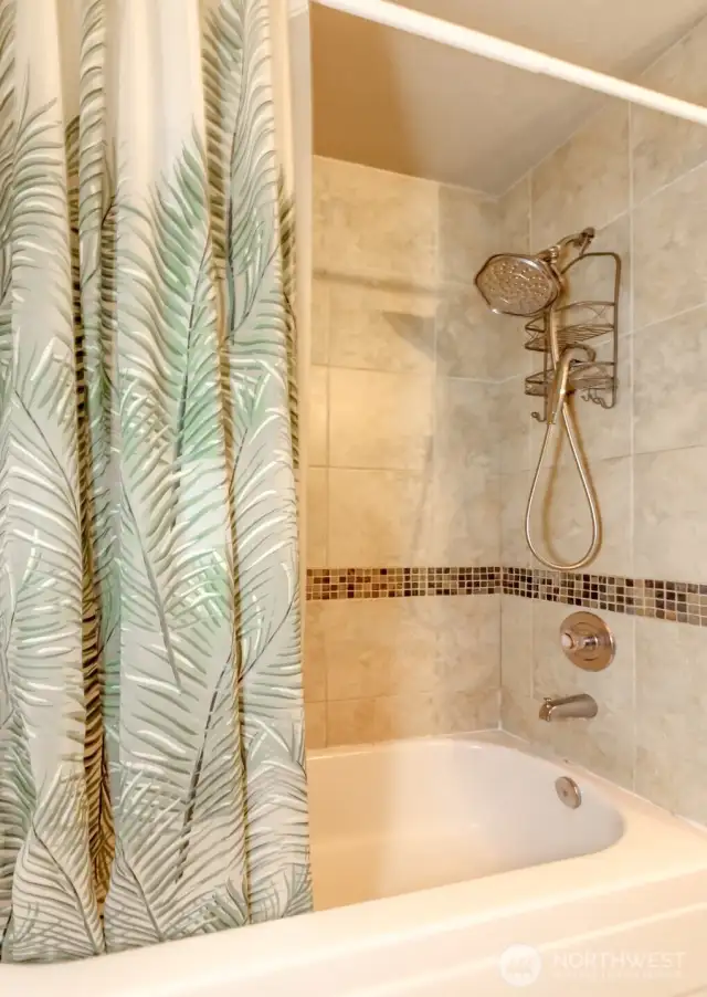 Designer tiled shower with rainforest showerhead.