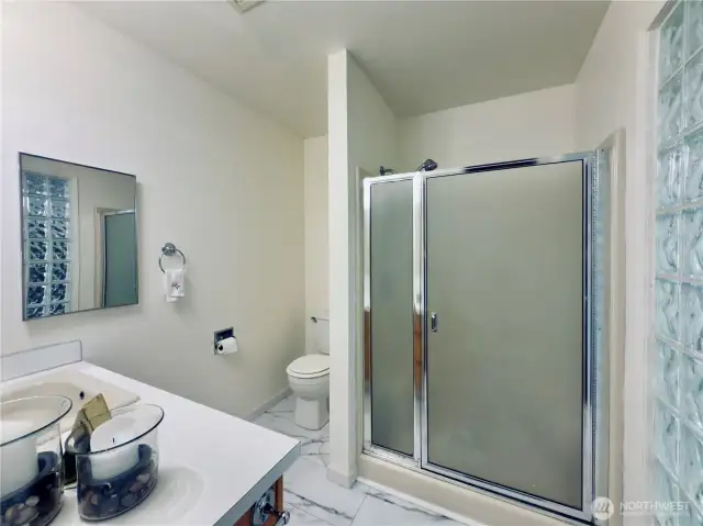Primary bathroom, glass block wall of light, new flooring, shower