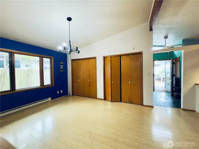 Dining room area, natural light, built-in shelving, two storage closets the length of the room, views to side yard, entryway, kitchen with bar seating