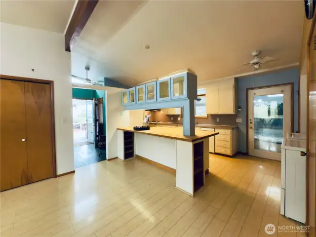 Dining room flows into the kitchen with countertop seating at the butcher-block counter, easy access to covered back patio and fenced backyard with apple tree and garden area