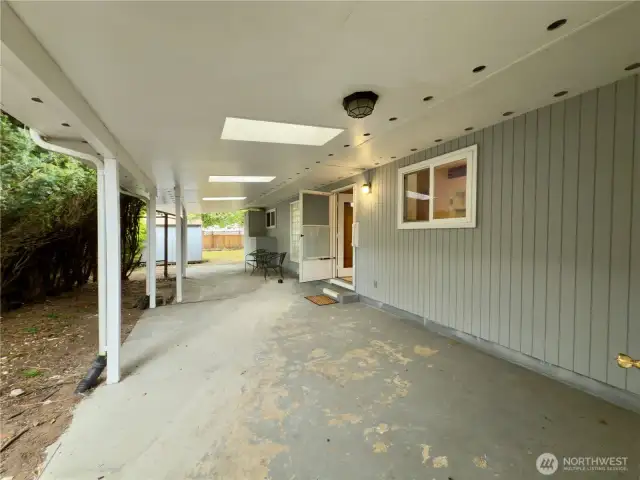 Covered back patio with access to kitchen and garage. Fenced backyard with outbuilding, apple tree, garden area