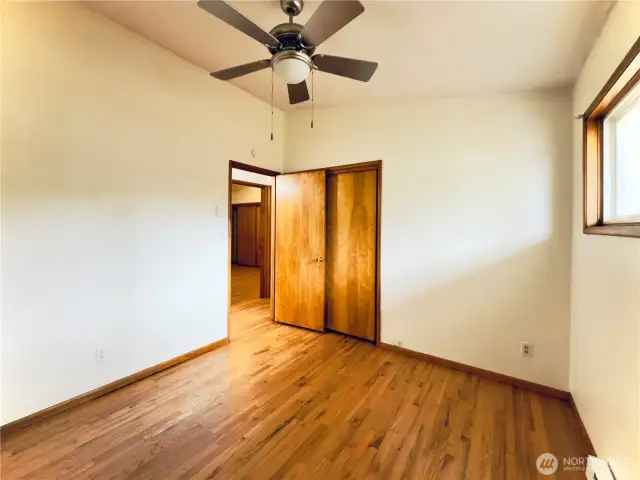 First bedroom, ceiling fan, vaulted ceiling, hardwood floor, move-in ready