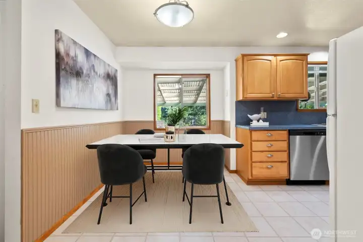 Adjacent to the kitchen, a bright and inviting nook is bathed in natural light from a large window, creating a cozy spot for casual meals, morning coffee, or quiet reading. Its charming setting makes it a perfect extension of the kitchen and a welcoming place to start the day.