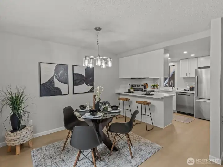 The generously sized dining area is adjacent to the kitchen and has room for bar seating. New light fixtures accent the space well.