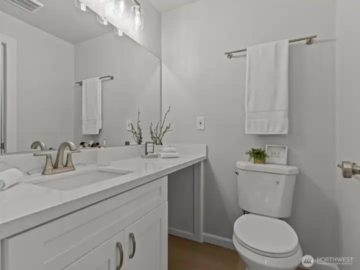 The other side of the bathroom has an oversized vanity with open space underneath for extra storage.