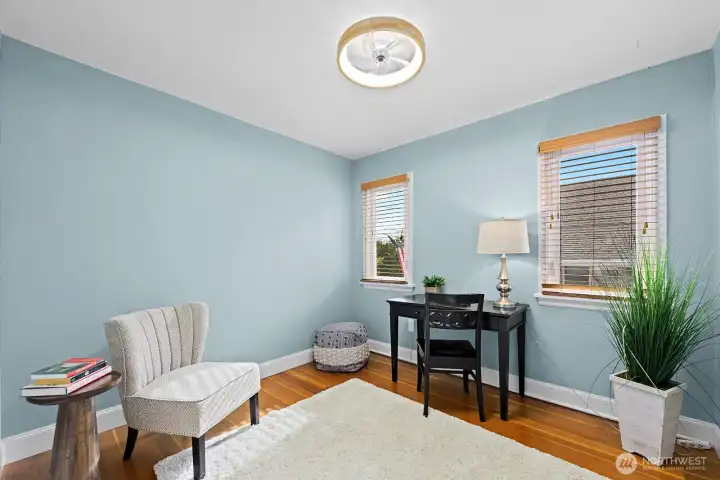 Flexible third bedroom on the main level or home office with hardwood floors, light filled windows—ideal for work or relaxation.