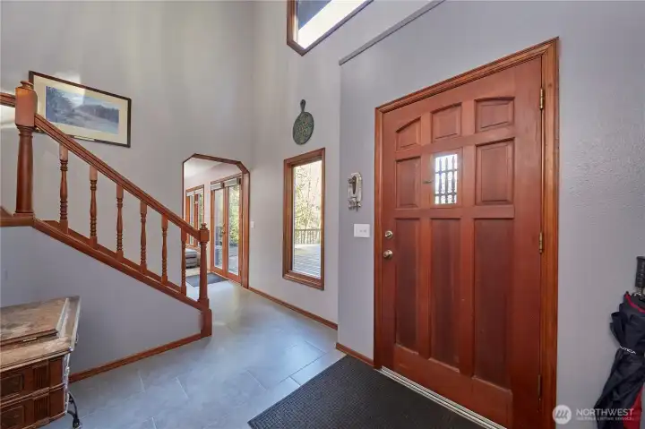Inviting entry way with tile flooring and wood windows.