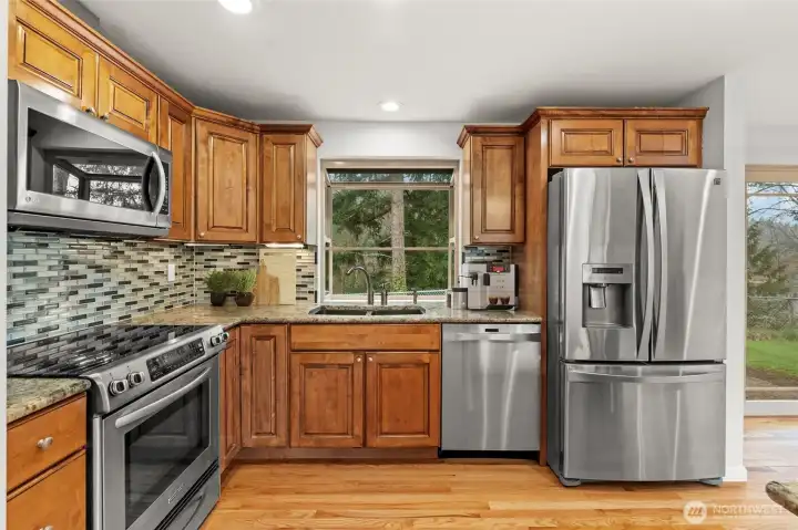 Stainless steel appliance package — French-door refrigerator, range, dishwasher, mosaic backsplash