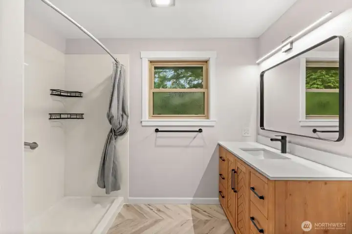 Updated upper bath — walk-in shower, chevron wood vanity, quartz counter, matte black fixtures