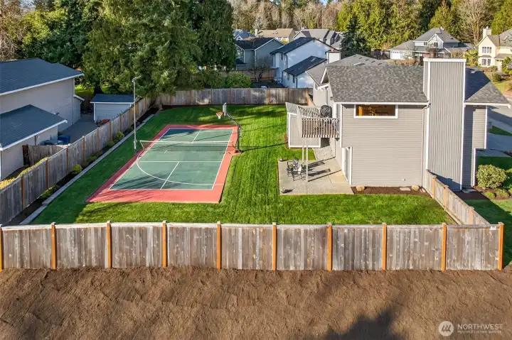 This aerial view highlights the standout combination of a large, fully fenced yard and an on site sports court, a rare lifestyle feature in this area. The 11,628 sf lot offers real usable space, with a layout that supports outdoor entertaining, play, and long term flexibility.